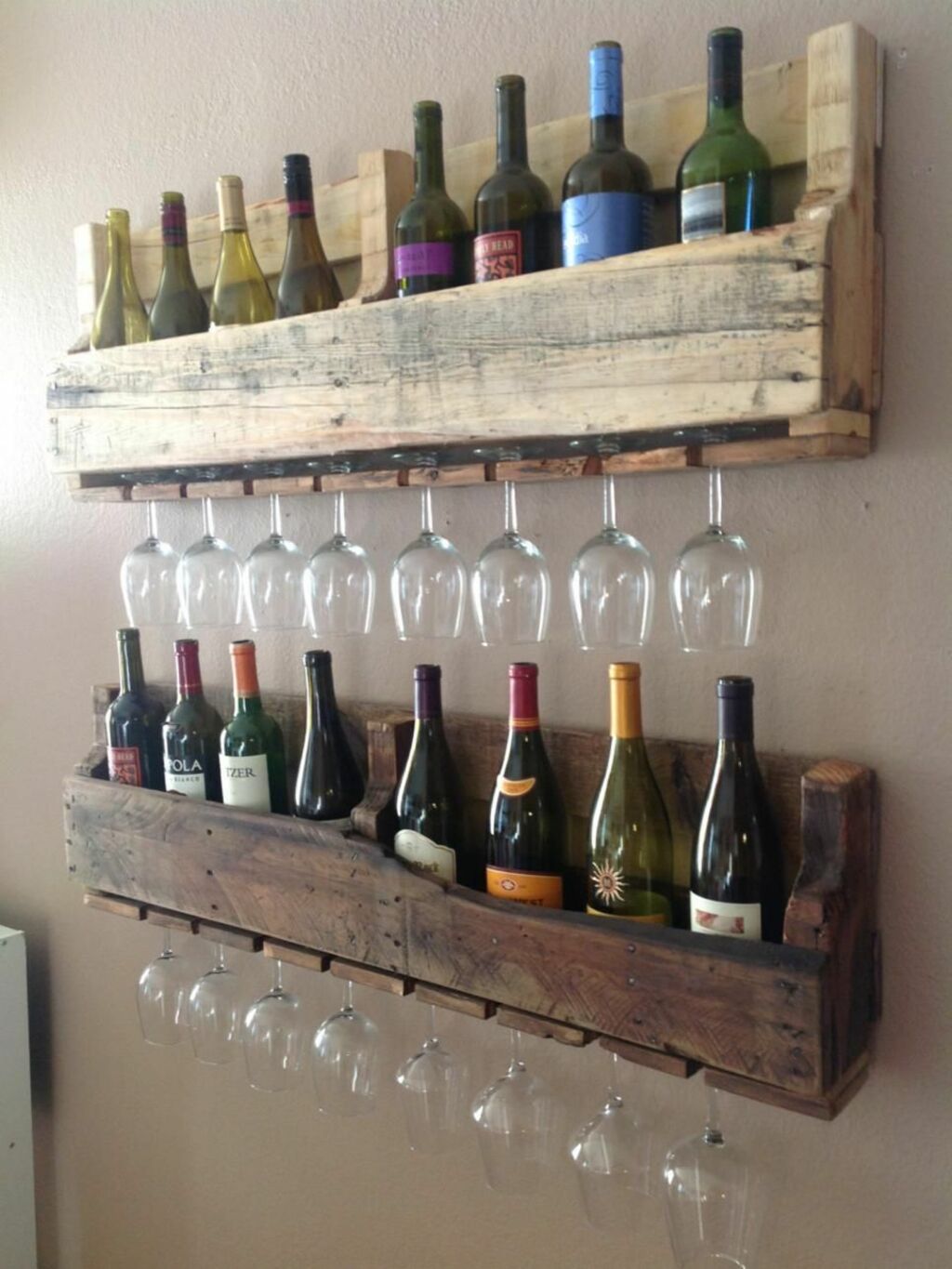 A wooden wine rack holding wine glasses and bottles
