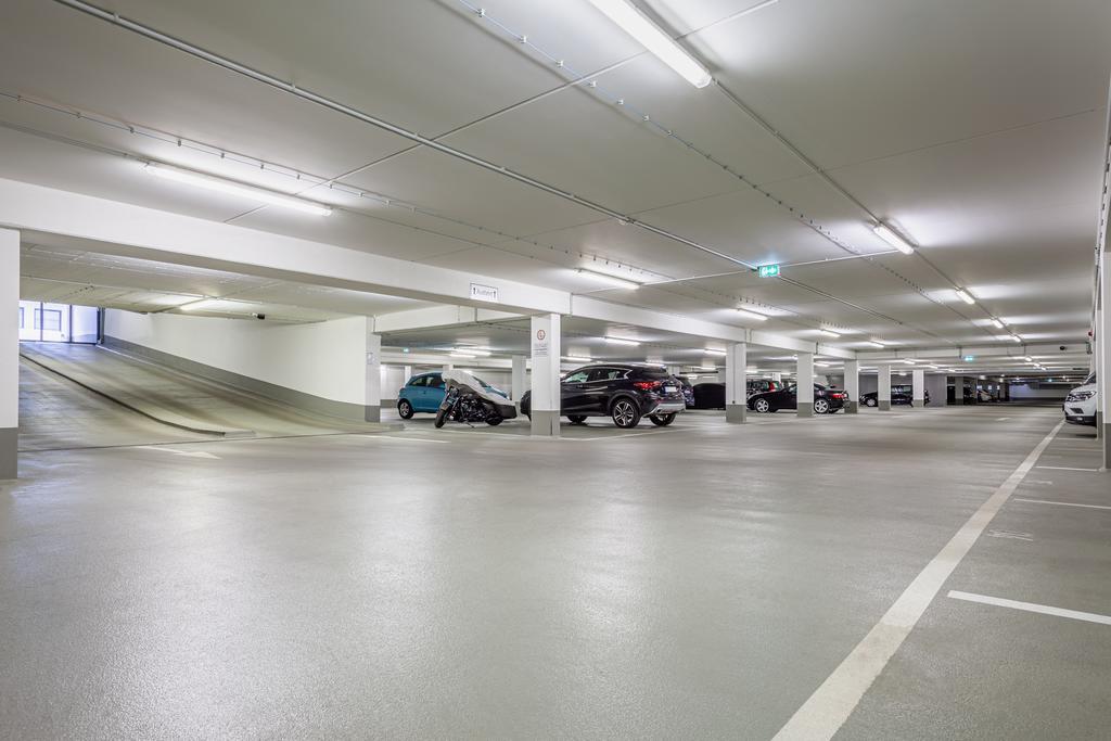 A parking garage with several cars parked in it
