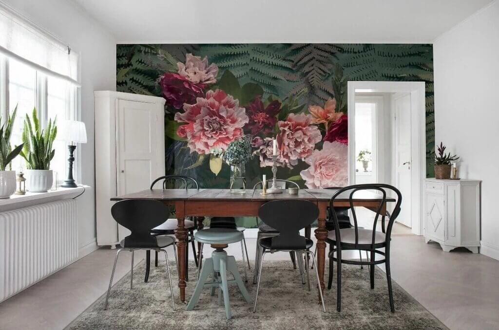 A dining room with a large floral wallpaper
