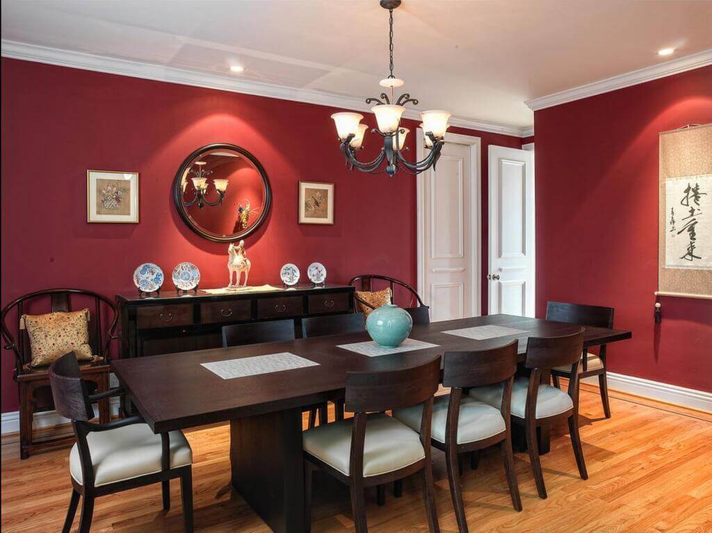 A dining room table and chairs with a clock on the wall
