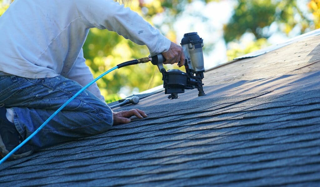 A man working on the roof of a house
