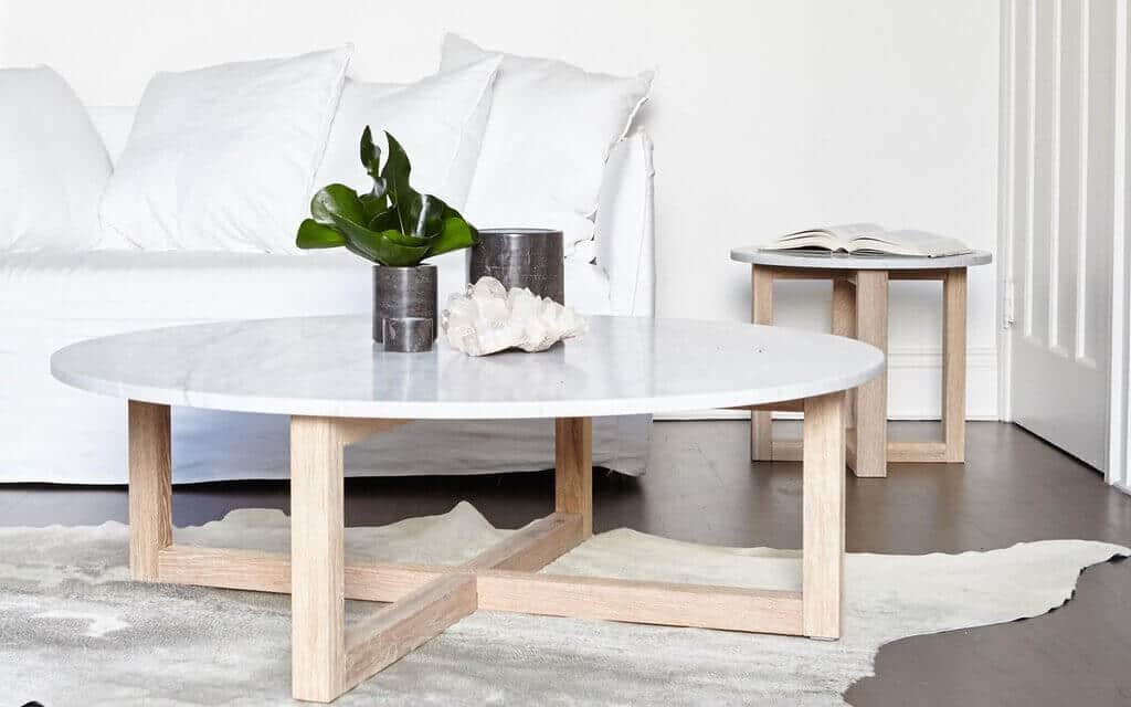 A living room with a white couch and a table
