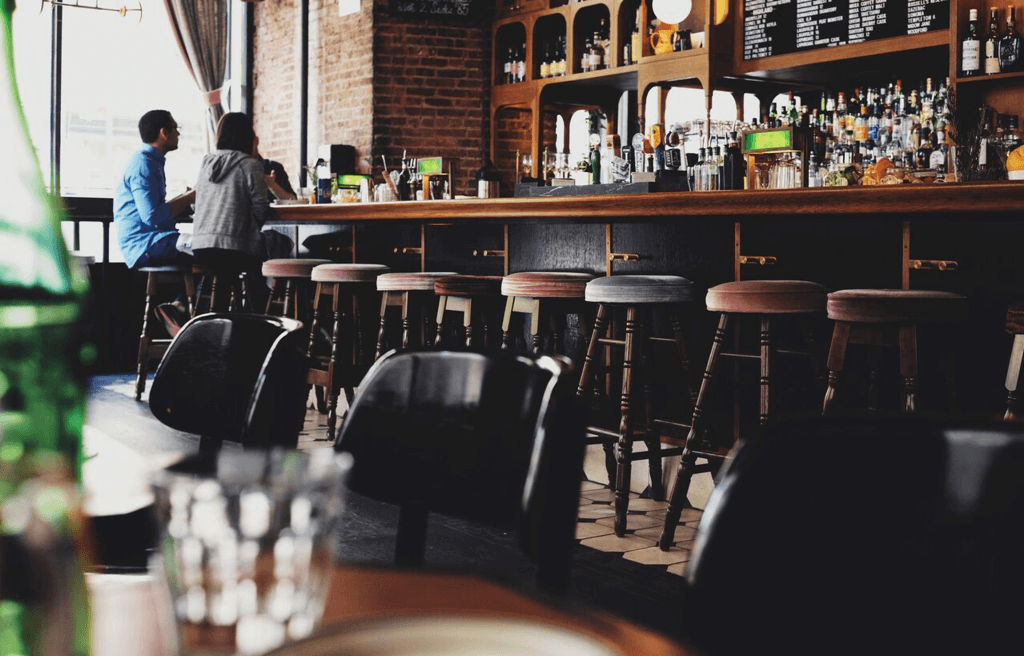 
A man and a woman standing at a bar
