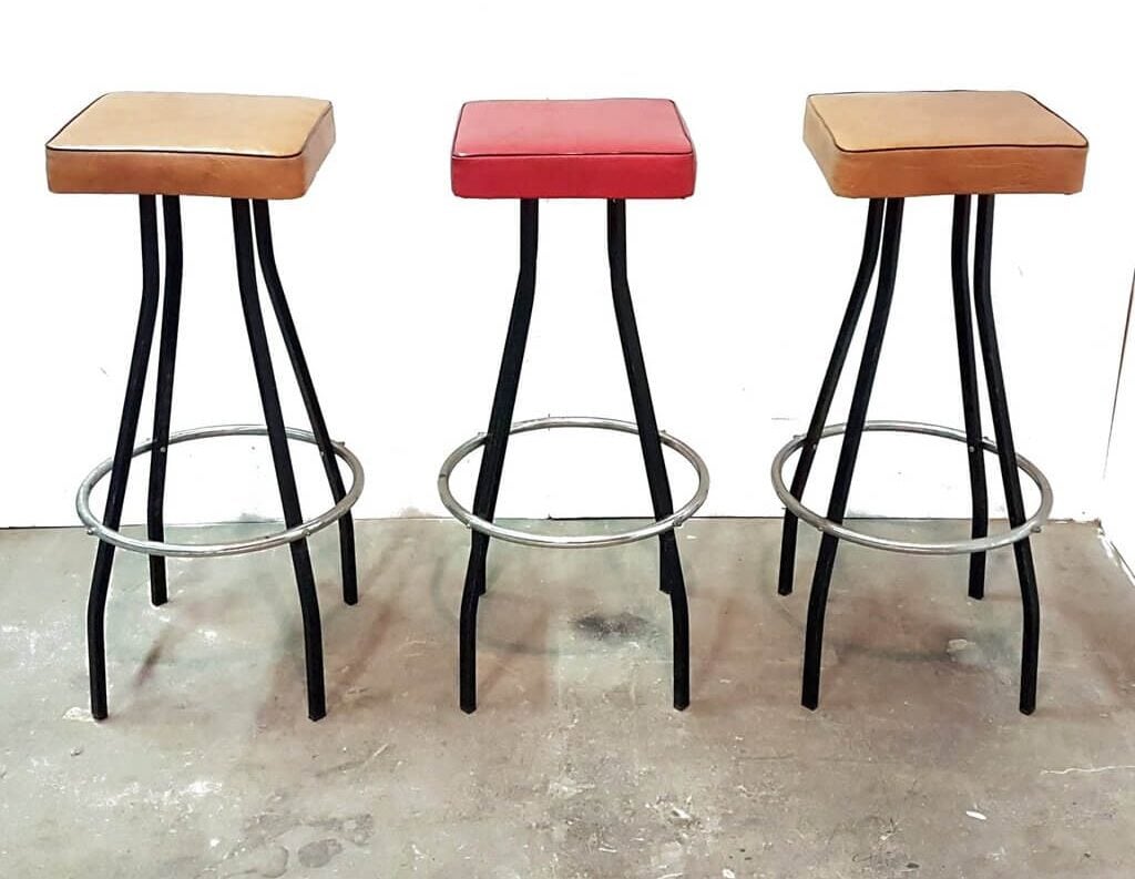 A couple of mid century modern bar stools sitting next to each other
