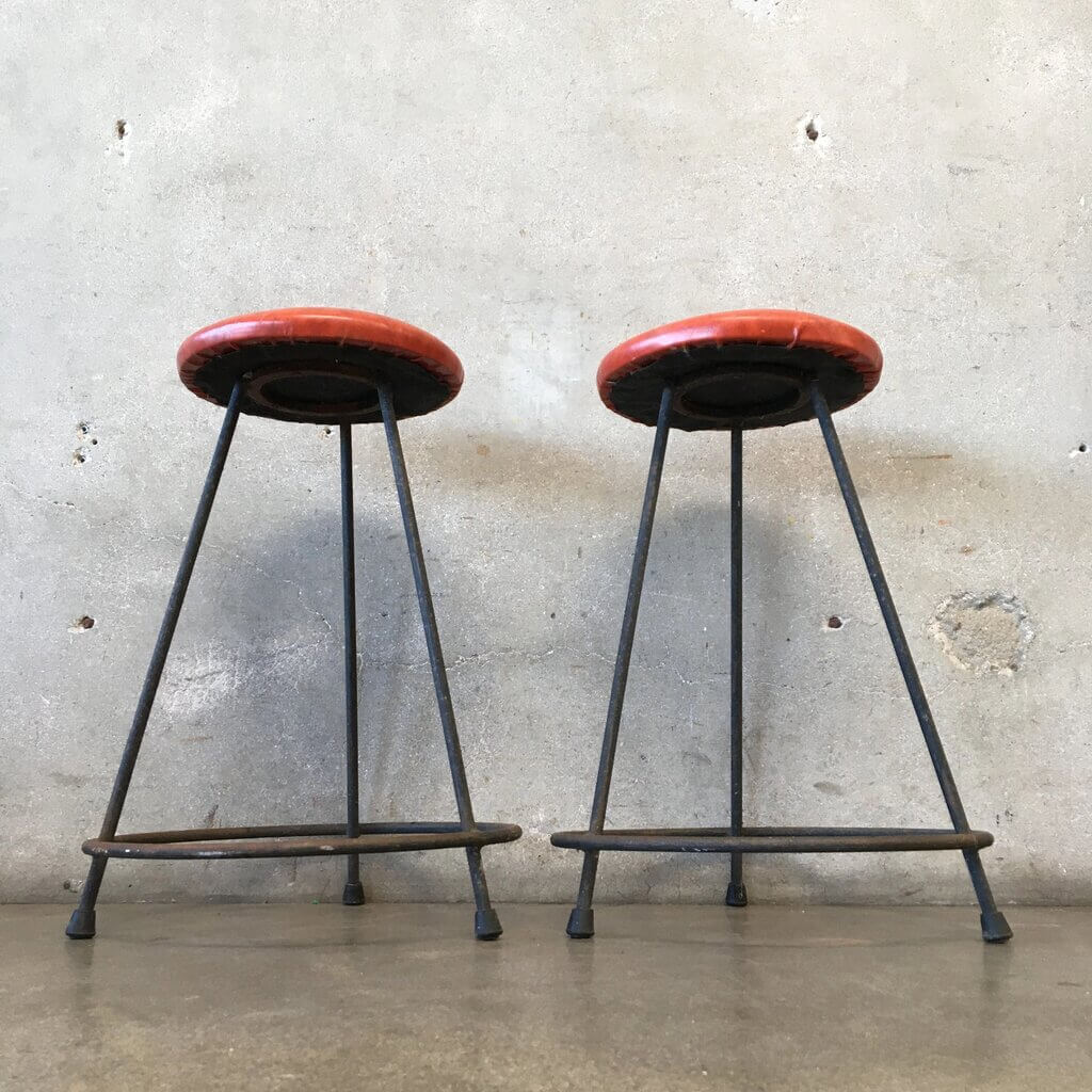A pair of mid century modern bar stools sitting next to each other
