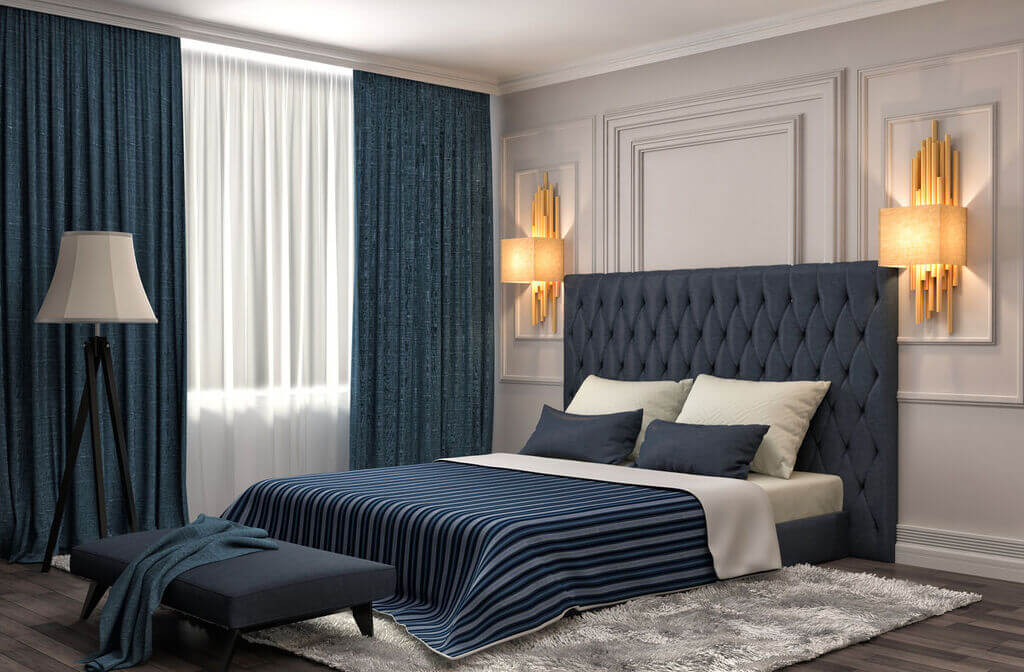 A bedroom with a large bed and a blue headboard
