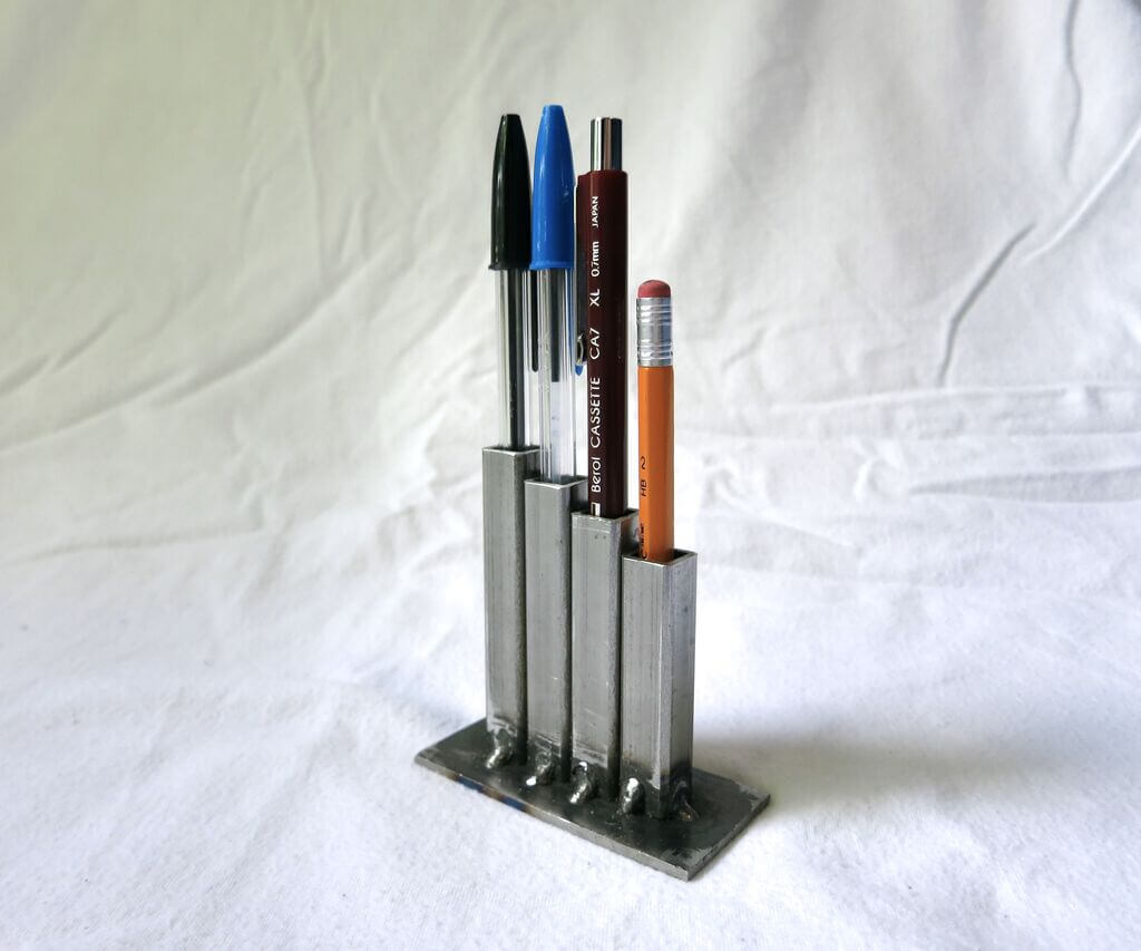 A pen holder with four pens in it
