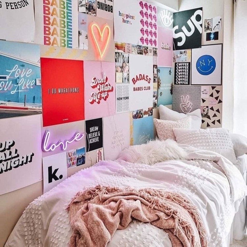 A bedroom with a bed covered in lots of posters
