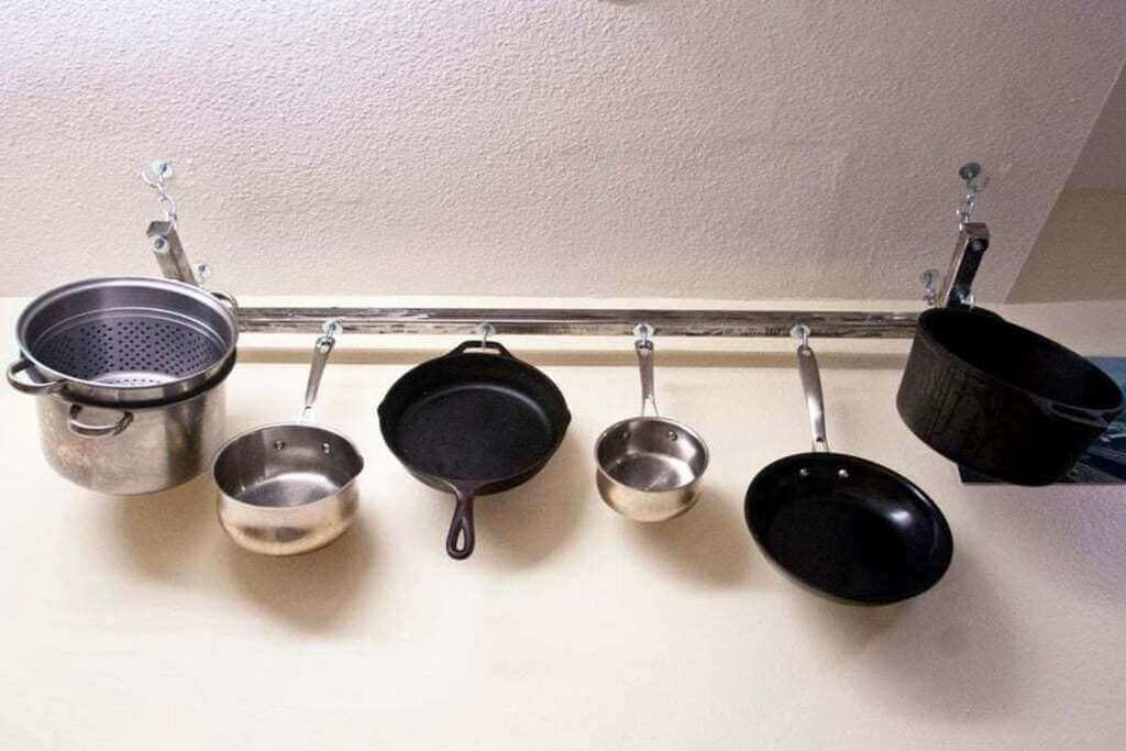 Pots and pans are hanging on a rack
