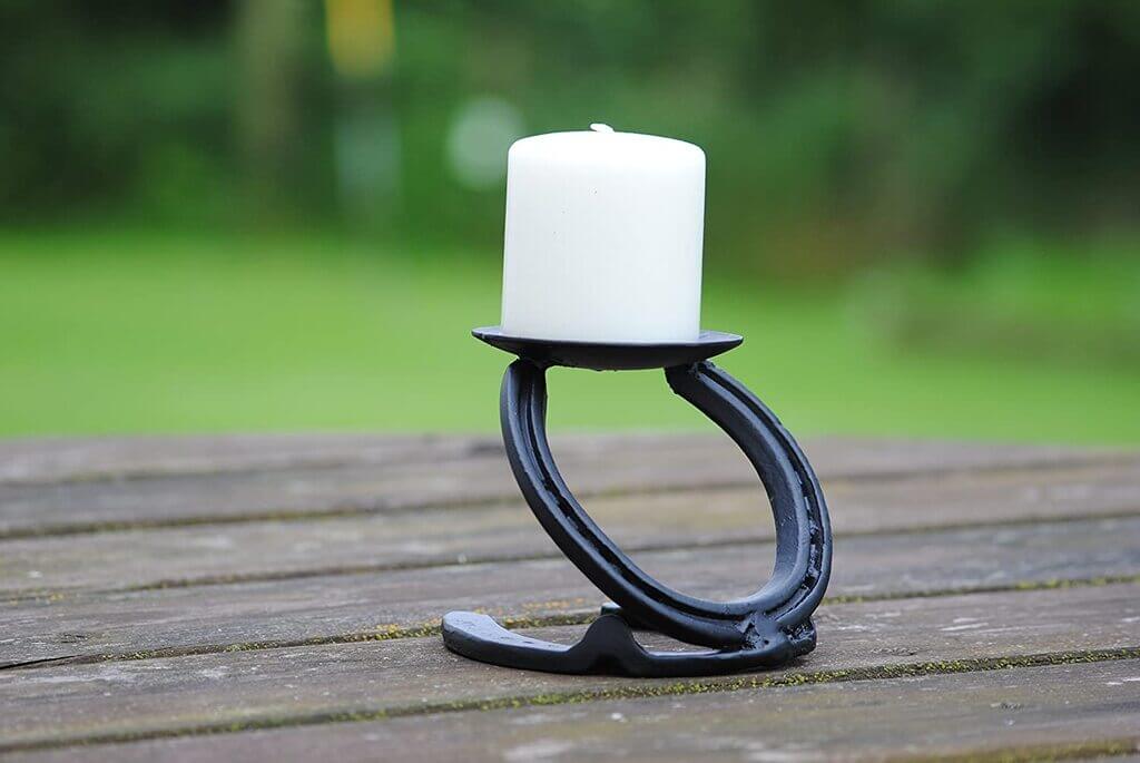 A black candle holder with a white candle on it
