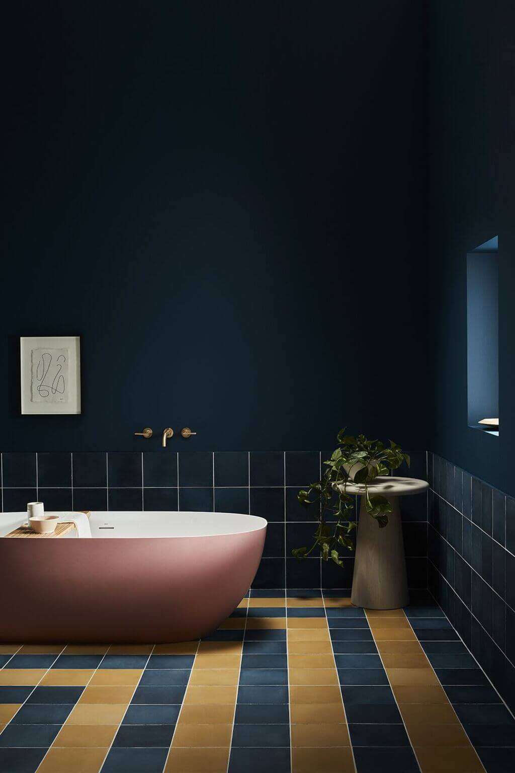 A bathroom with a bathtub and a plant in the corner
