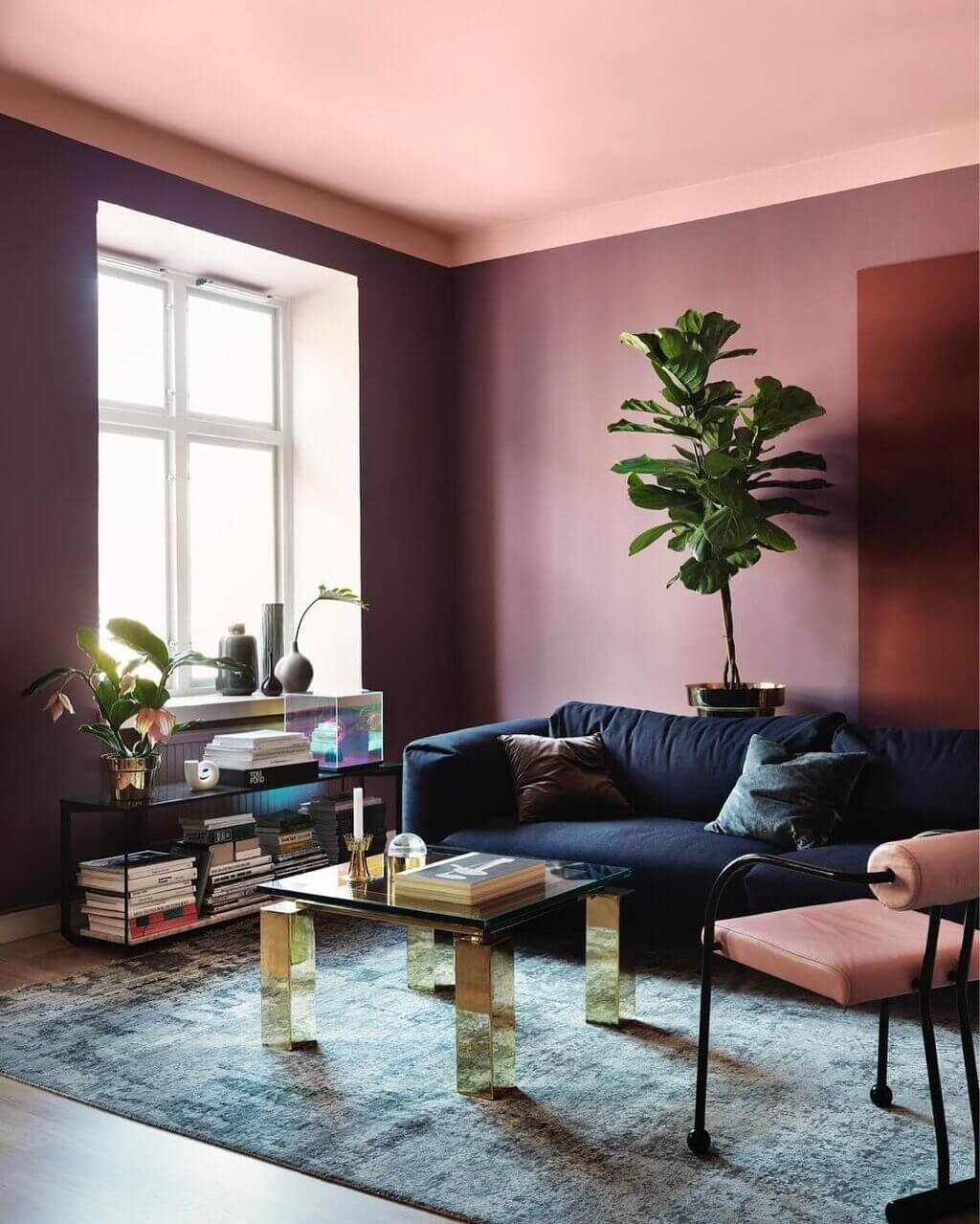 A living room with purple walls and a blue couch
