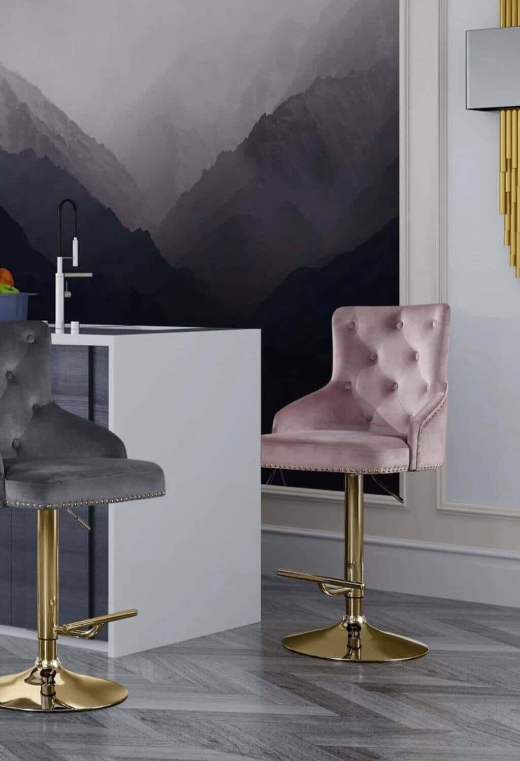 A pair of grey and gold bar stools in front of a wall with a
