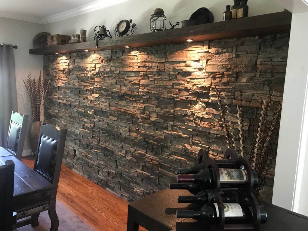 A dining room with a stone wall and wooden table
