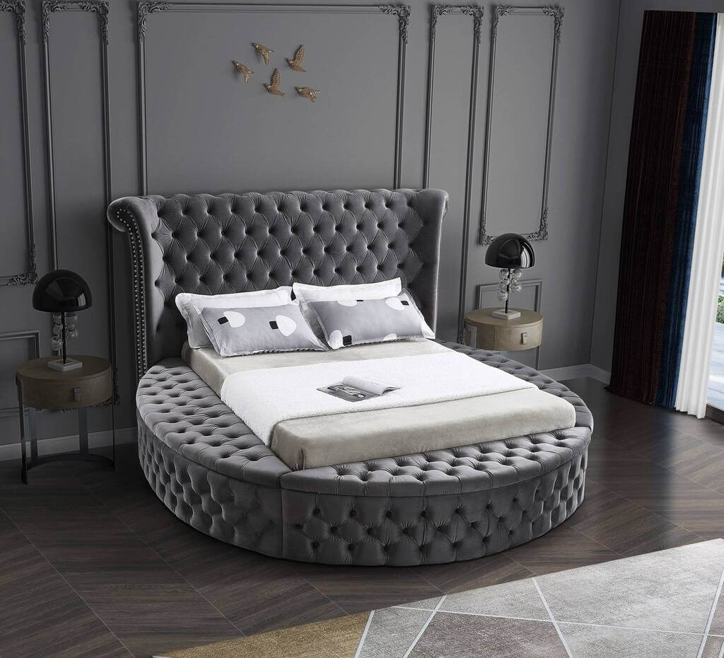 A round bed with a white blanket on top of it
