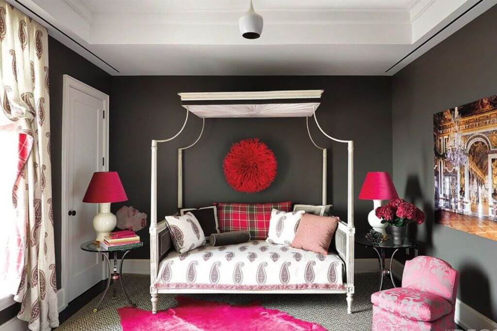 A bedroom with a canopy bed and a pink rug
