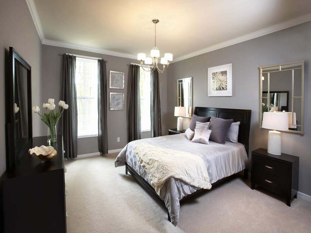 A bedroom with a large bed and a chandelier
