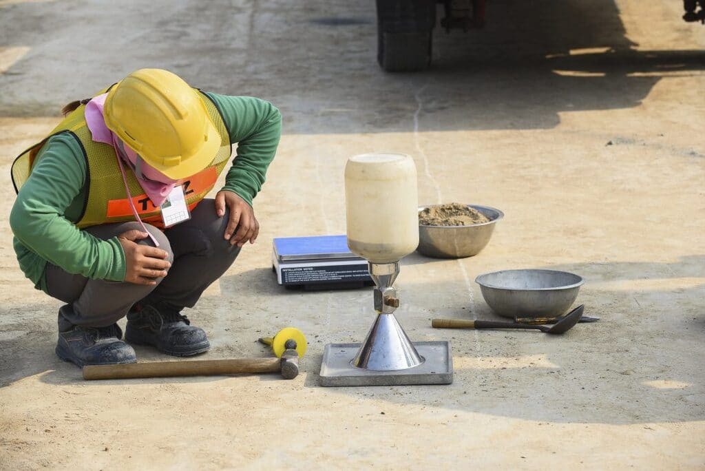A man kneeling down on the ground next to tools
