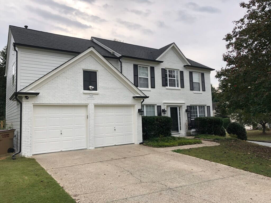 A white two story house with black shutters
