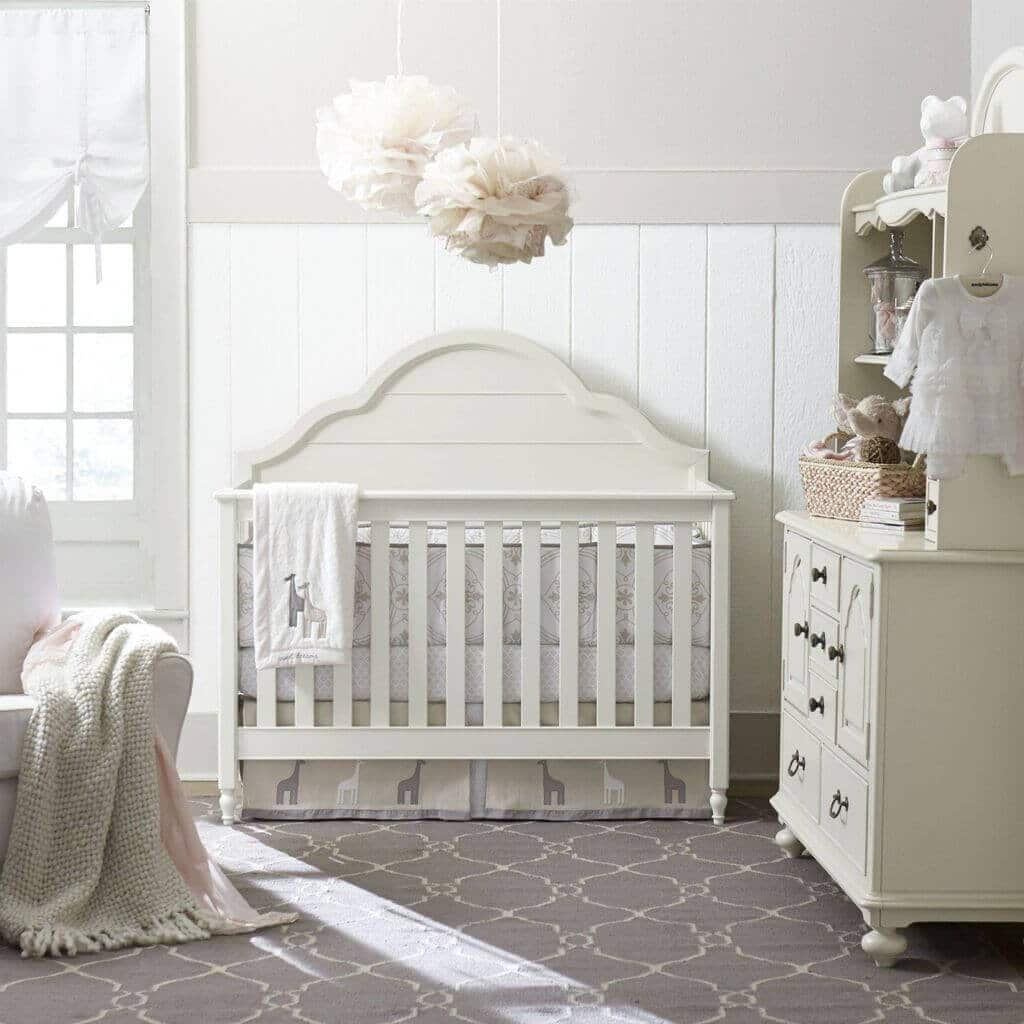A baby's room with a crib, dresser, and bed
