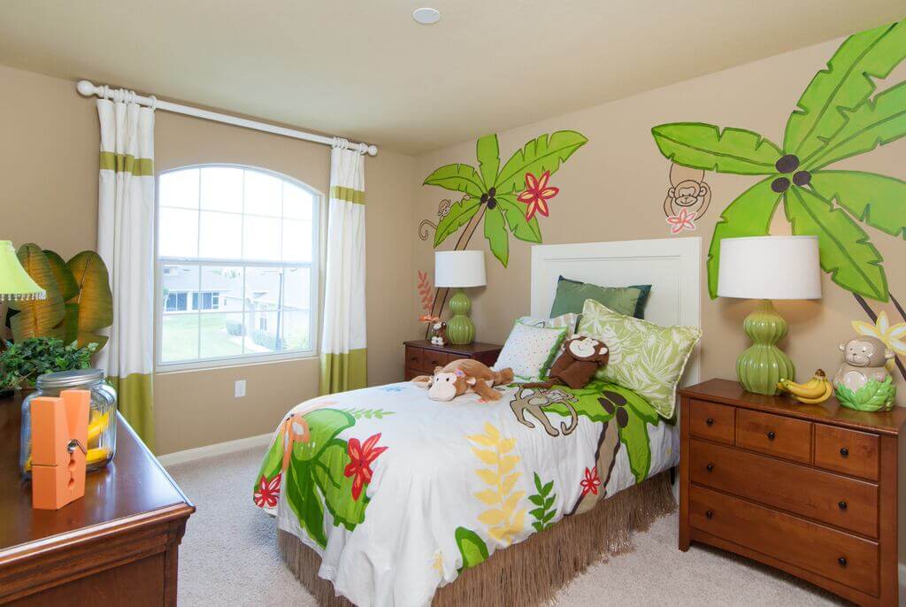 A bedroom with a tropical theme painted on the wall
