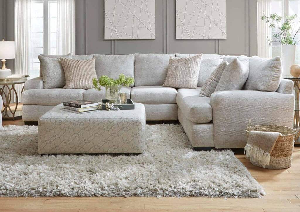 A living room filled with grey sofa and a white rug
