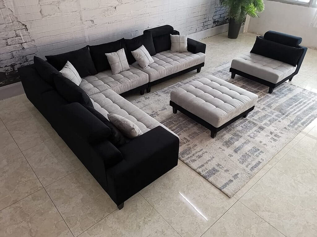 A living room filled with black and grey sofa and a rug
