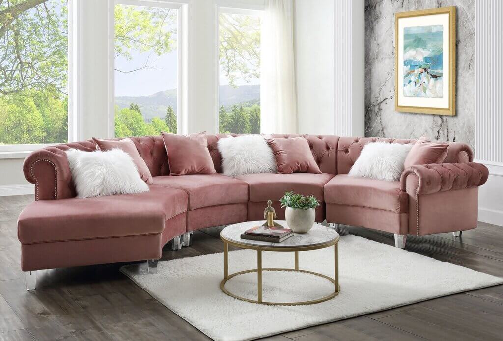 A living room with a pink sofa and a white rug
