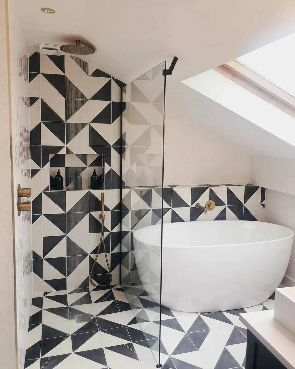 A black and white tiled bathroom with a free standing tub
