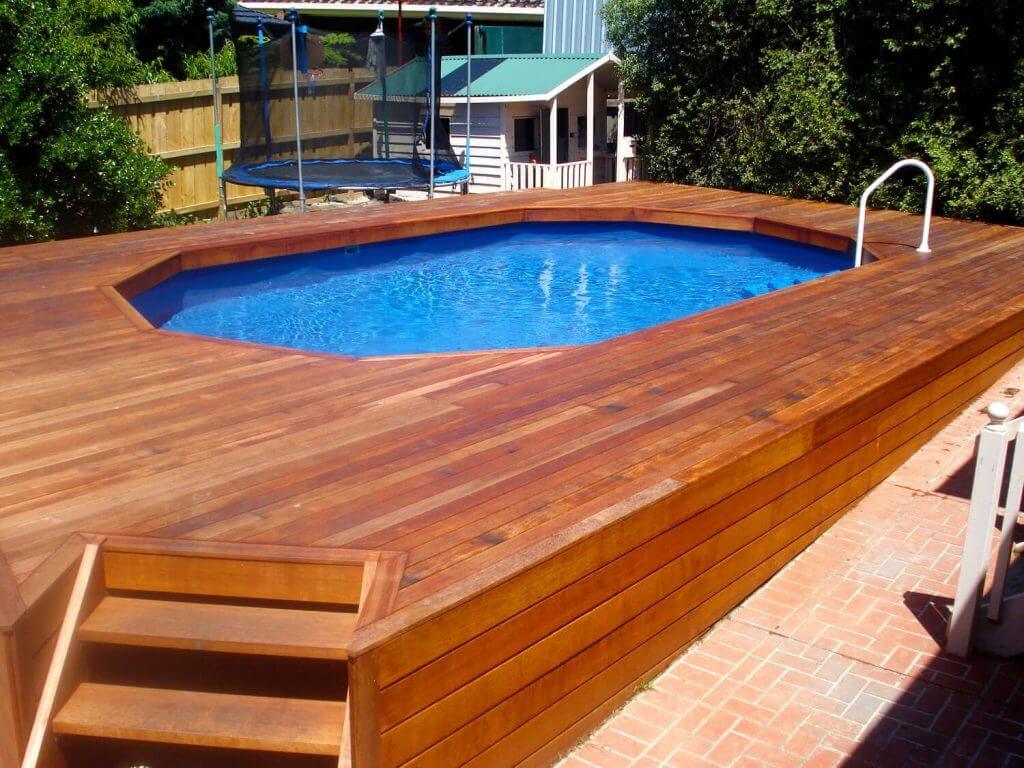 A wooden deck with a pool in the middle of it

