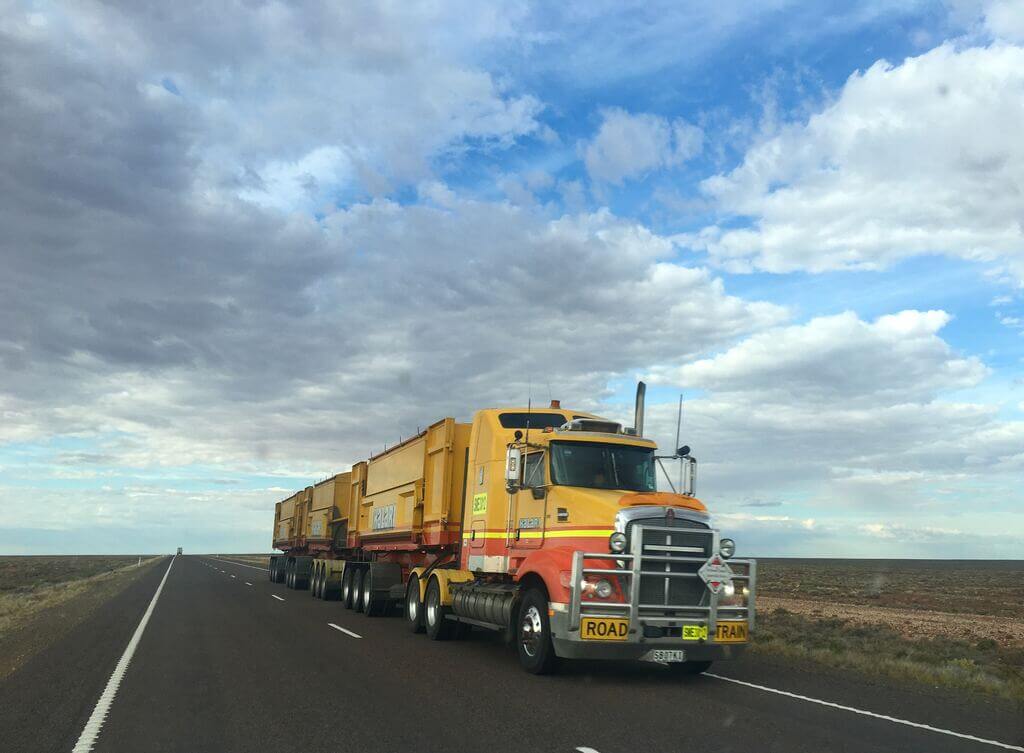 Long-Distance Moving: A yellow and red truck driving down a road
