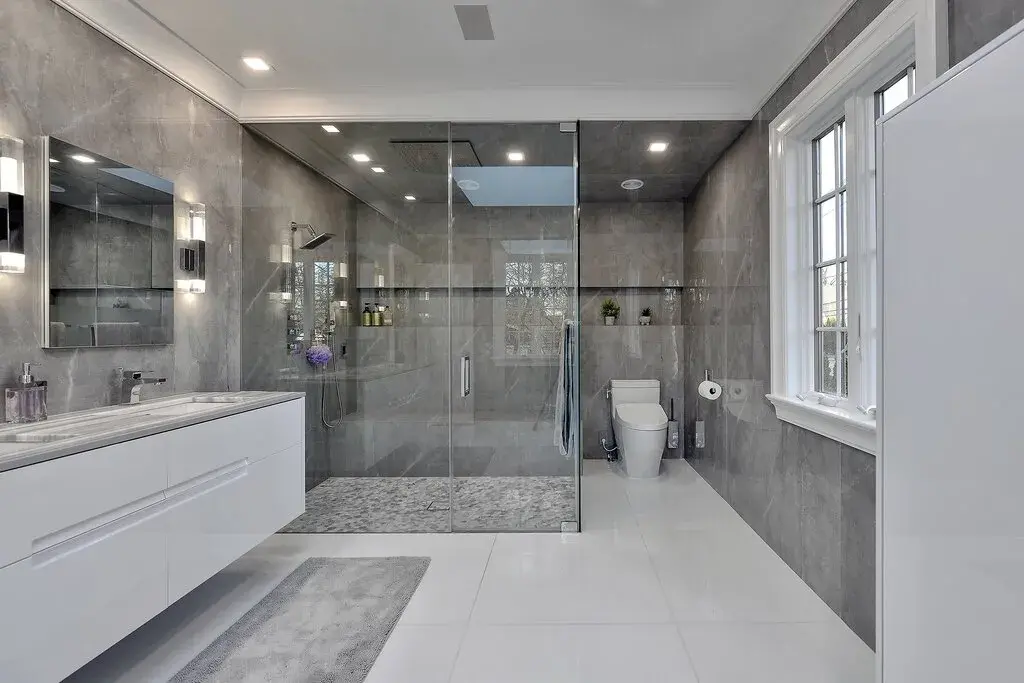 A bathroom with a walk in shower next to a sink
