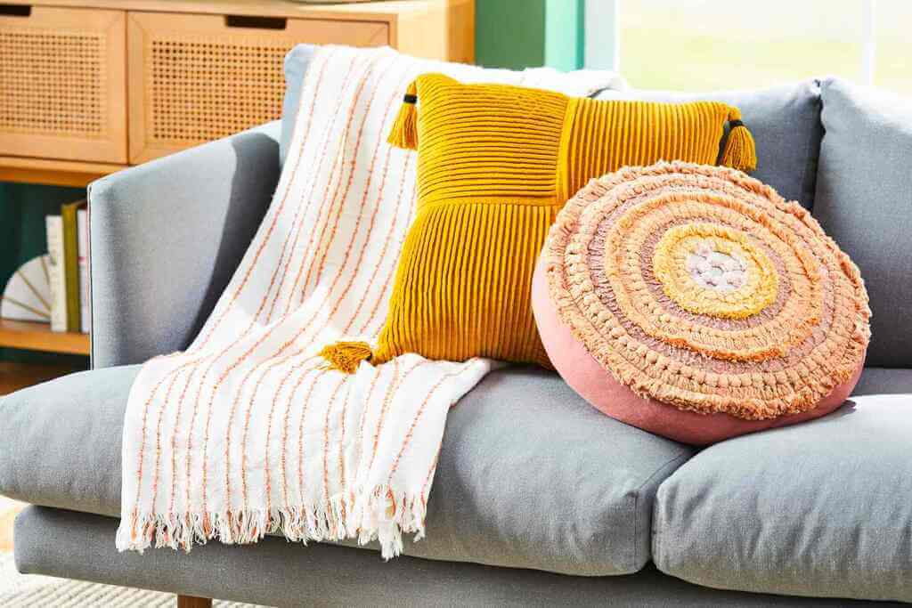 A gray couch with yellow and white pillows
