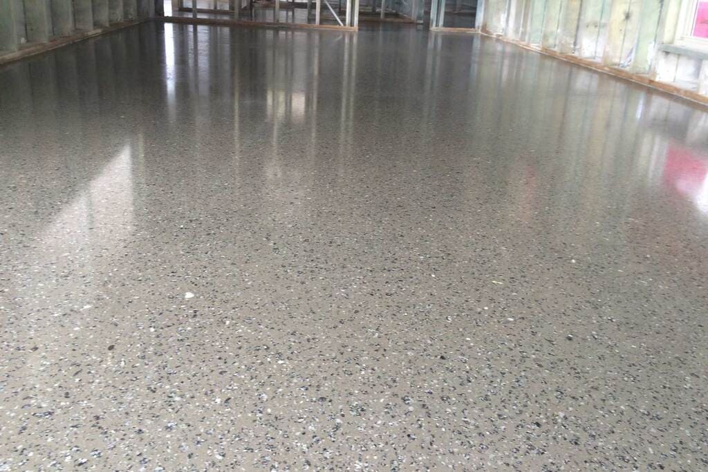 A large room with a shiny Honed Concrete floor and walls
