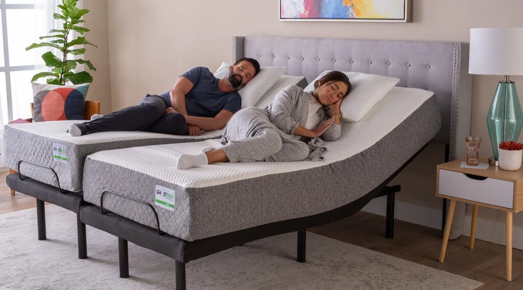 A couple of people laying on top of a Adjustable Bed Frame