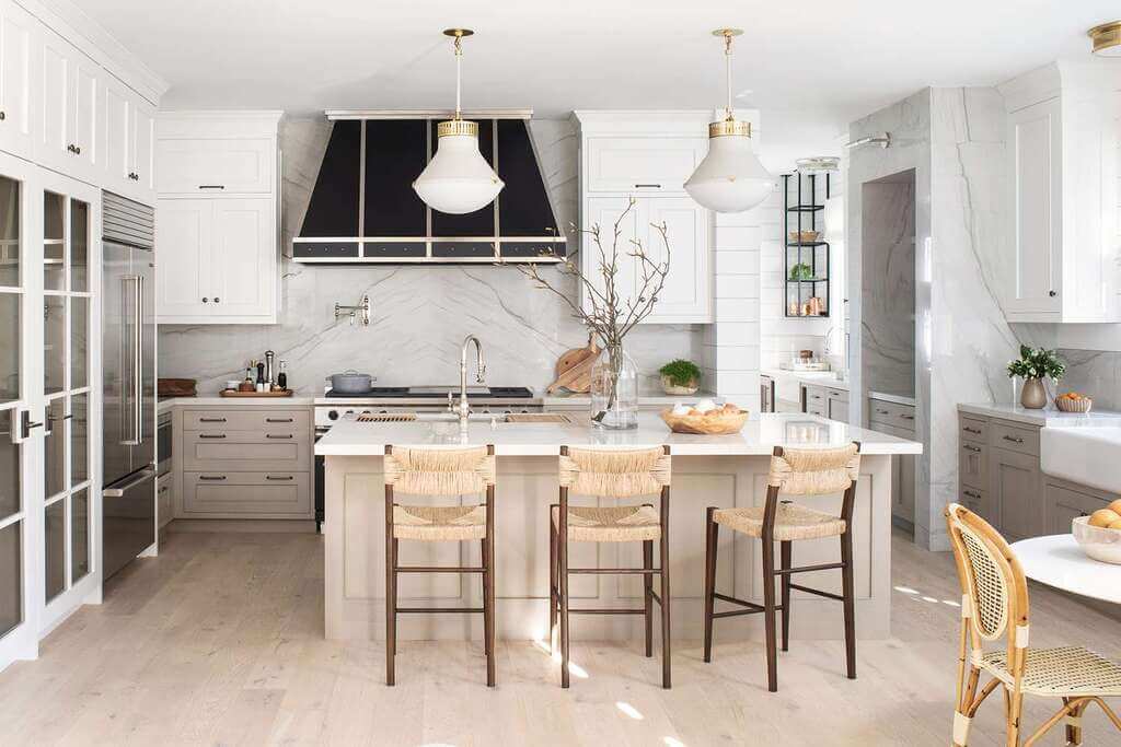 A large kitchen with a center island with chairs
